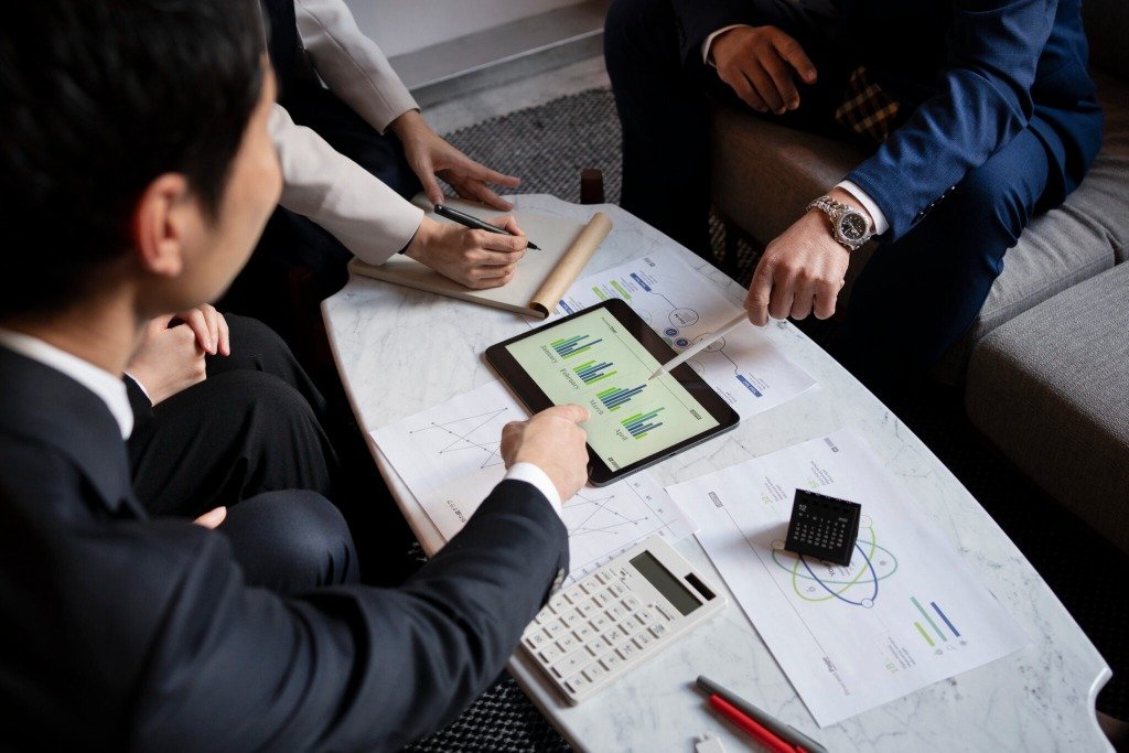Business professionals reviewing maritime data and charts